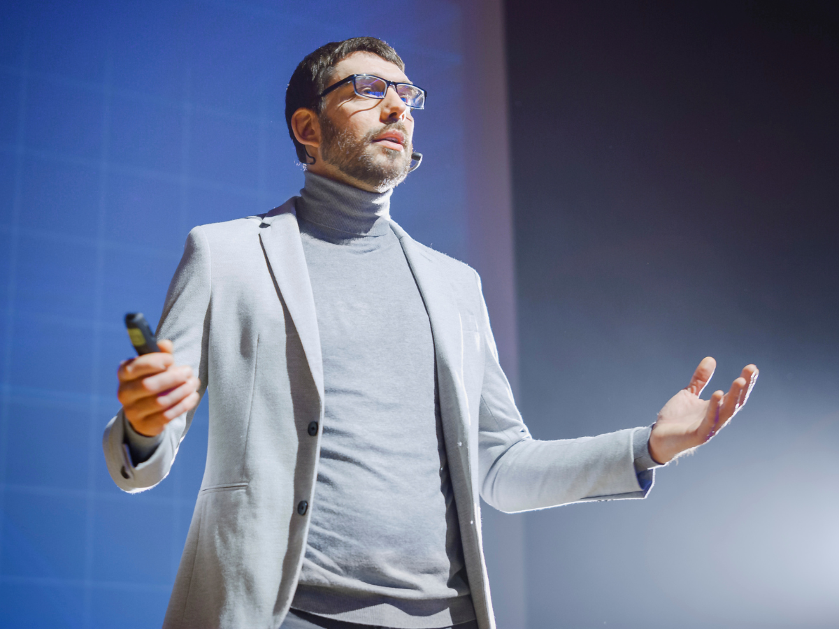 Man demonstrating business communication skills on a stage.
