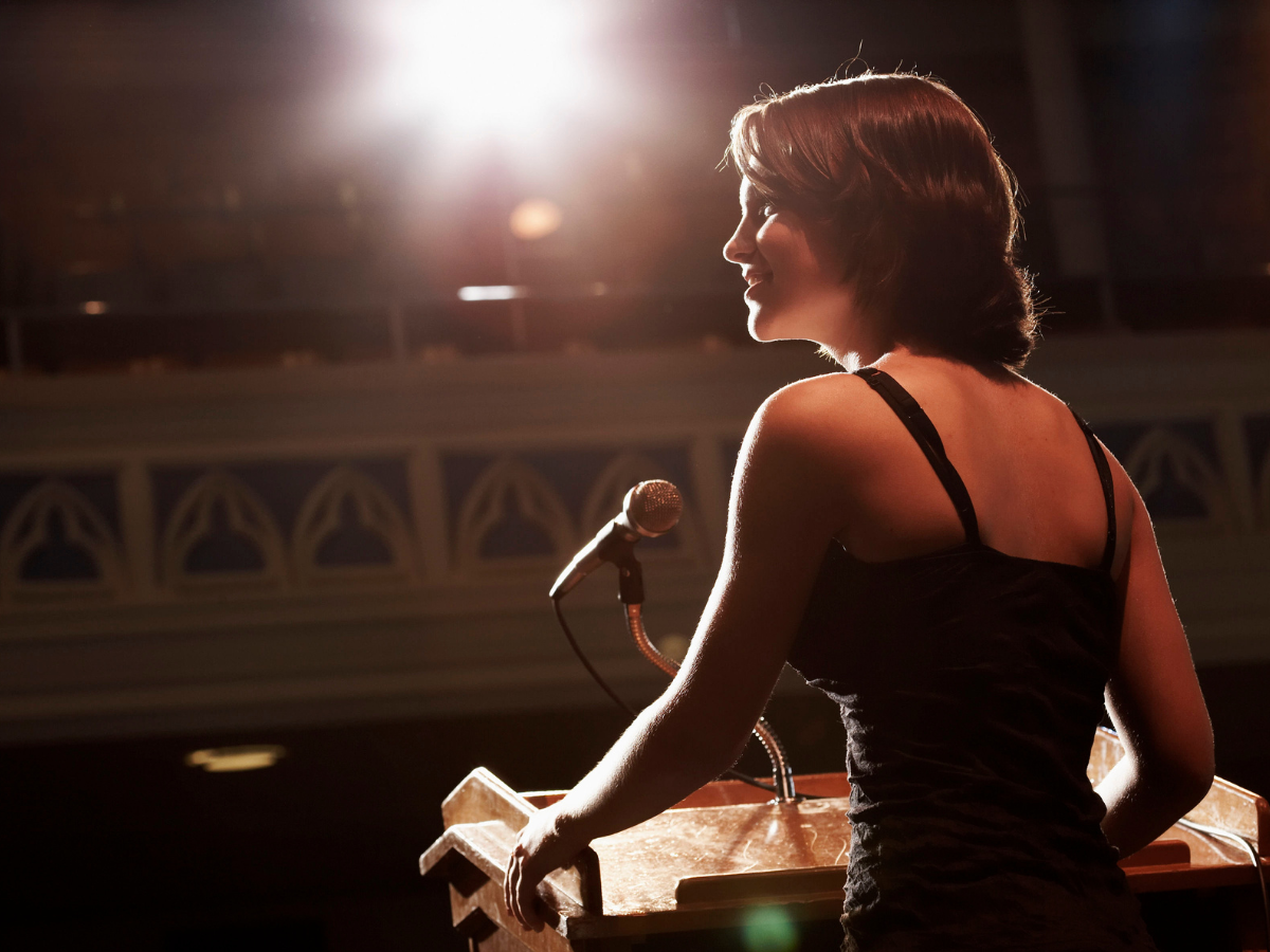 Woman using storytelling while speaking on a stage
