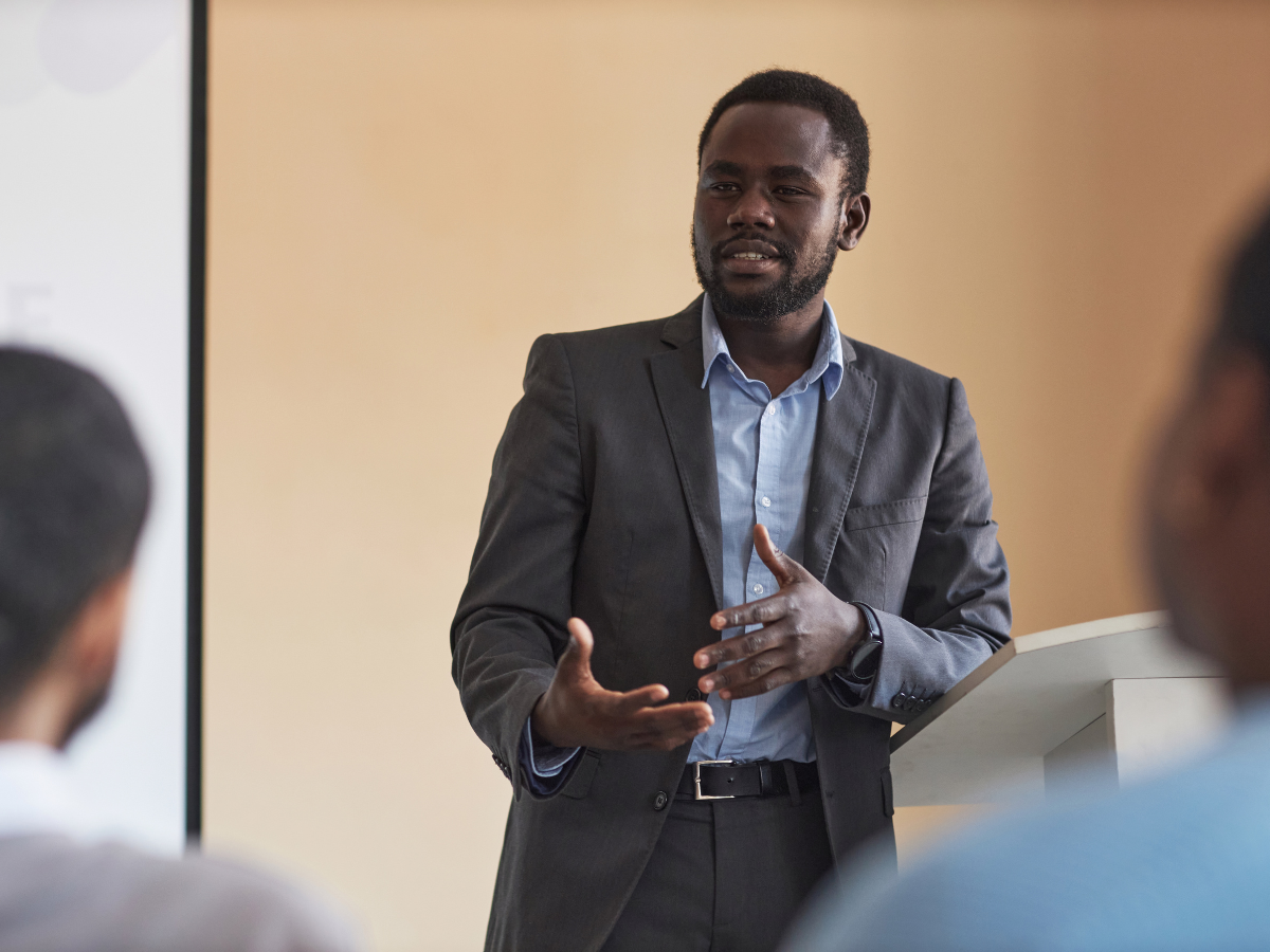 Man is suit giving a prepared presentation